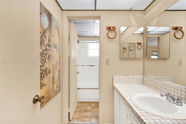 full bath featuring tile patterned floors, decorative backsplash, vanity, and washtub / shower combination