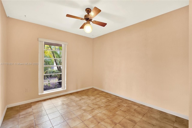 spare room featuring light tile patterned floors, a ceiling fan, and baseboards