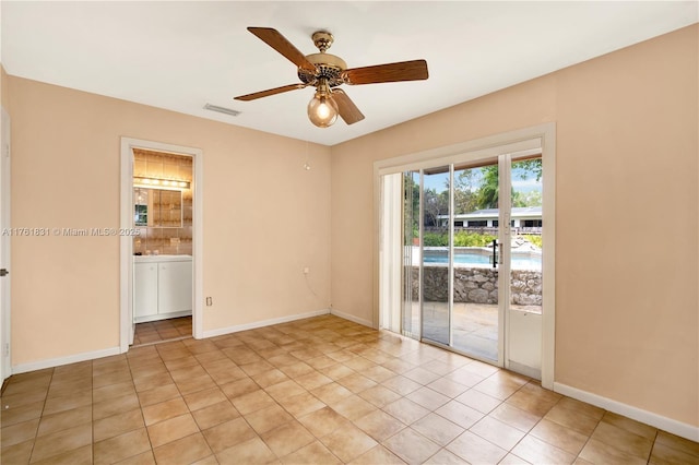 empty room featuring light tile patterned flooring, visible vents, a ceiling fan, and baseboards