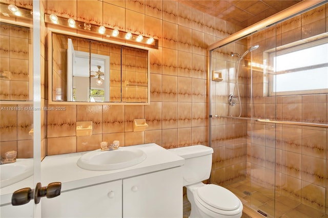 full bath with vanity, a shower stall, tile walls, toilet, and tasteful backsplash