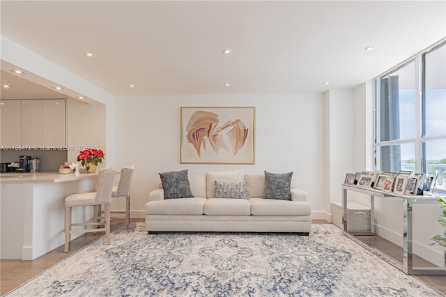 living area featuring recessed lighting, baseboards, and light wood-style floors