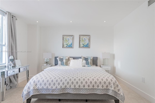 bedroom featuring multiple windows, baseboards, visible vents, and light carpet