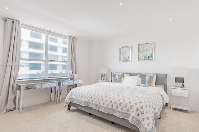 bedroom featuring light colored carpet and baseboards