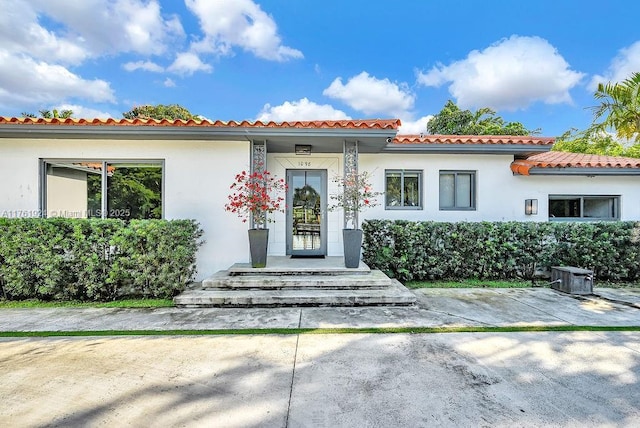 mediterranean / spanish home with a tile roof and stucco siding