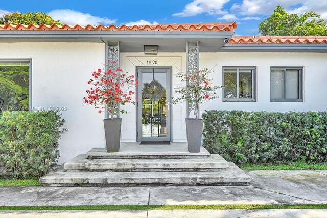 property entrance with stucco siding and a porch