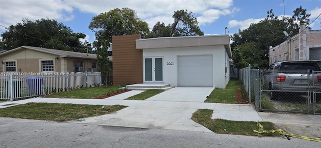 view of front of house with an attached garage, a fenced front yard, stucco siding, and concrete driveway