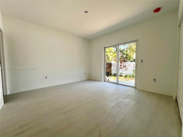 empty room featuring baseboards and light wood-type flooring