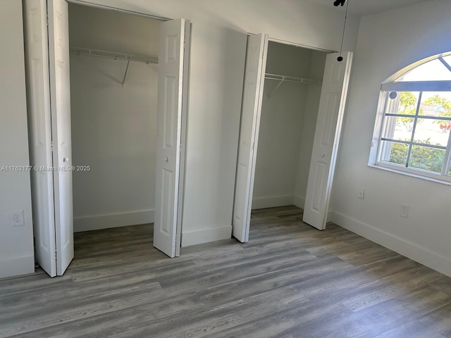 unfurnished bedroom featuring wood finished floors and baseboards