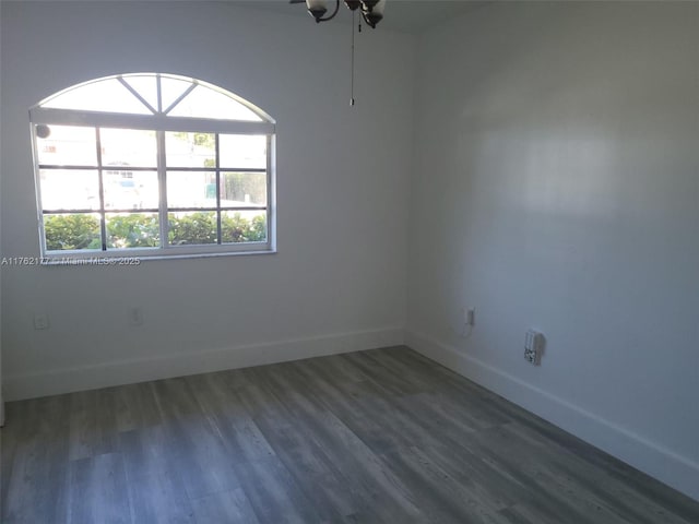 empty room with baseboards and wood finished floors