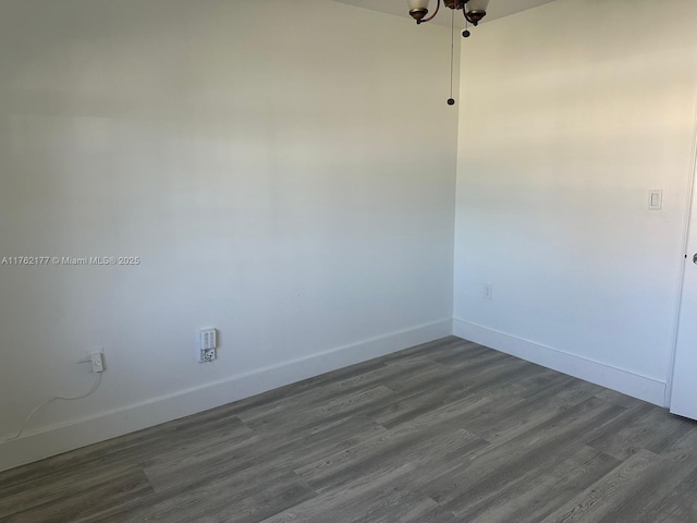 spare room with dark wood finished floors and baseboards