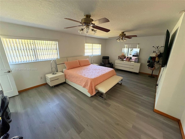 bedroom featuring baseboards, a textured ceiling, and wood finished floors