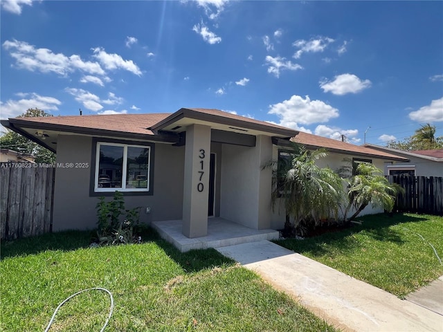 3170 NW 92nd St, Miami, FL 33147 - ranch-style home with stucco siding, fence, and a front yard
