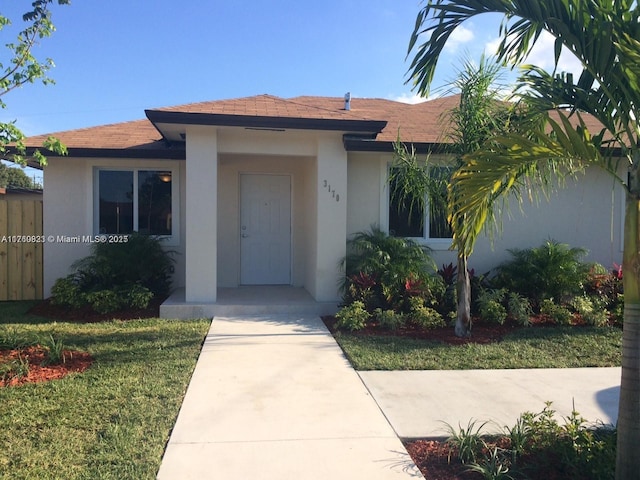 view of front of property with stucco siding and a front yard