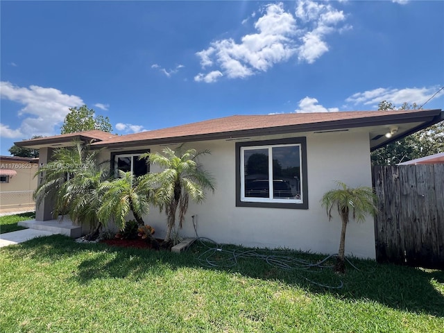 3170 NW 92nd St, Miami, FL 33147 - view of side of property featuring a yard, stucco siding, and fence