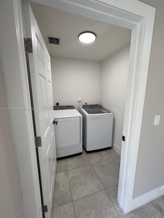 3170 NW 92nd St, Miami, FL 33147 - washroom featuring light tile patterned flooring, laundry area, washing machine and clothes dryer, and visible vents