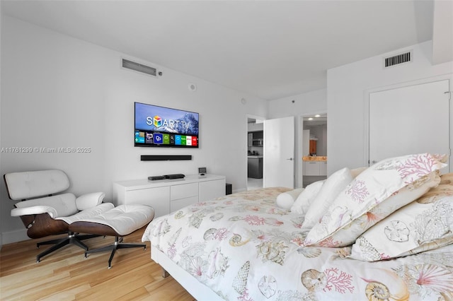 500 Brickell Ave Unit 2510, Miami, FL 33131 - bedroom with ensuite bath, visible vents, and light wood-type flooring