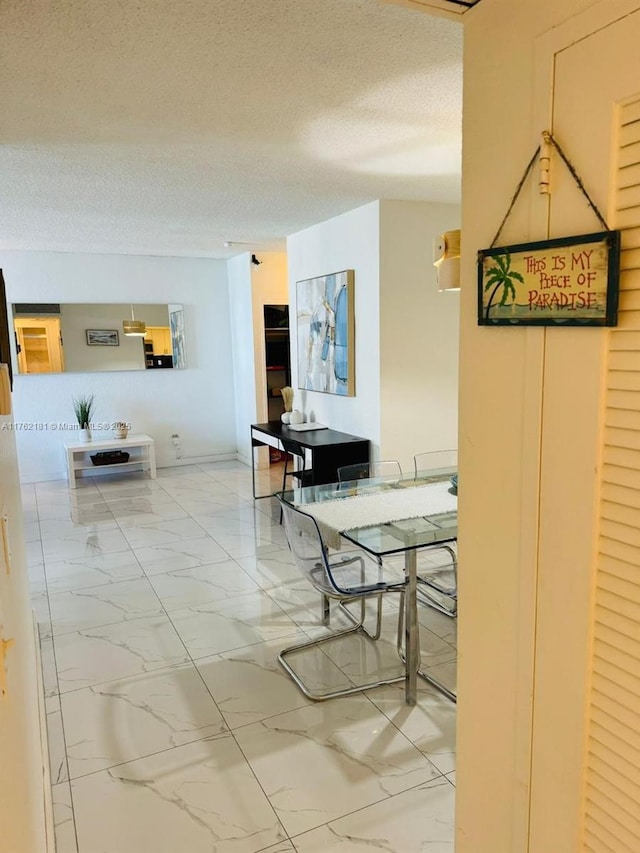 dining room featuring marble finish floor and a textured ceiling