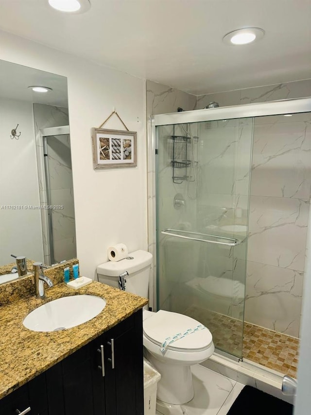 bathroom featuring a marble finish shower, toilet, recessed lighting, marble finish floor, and vanity