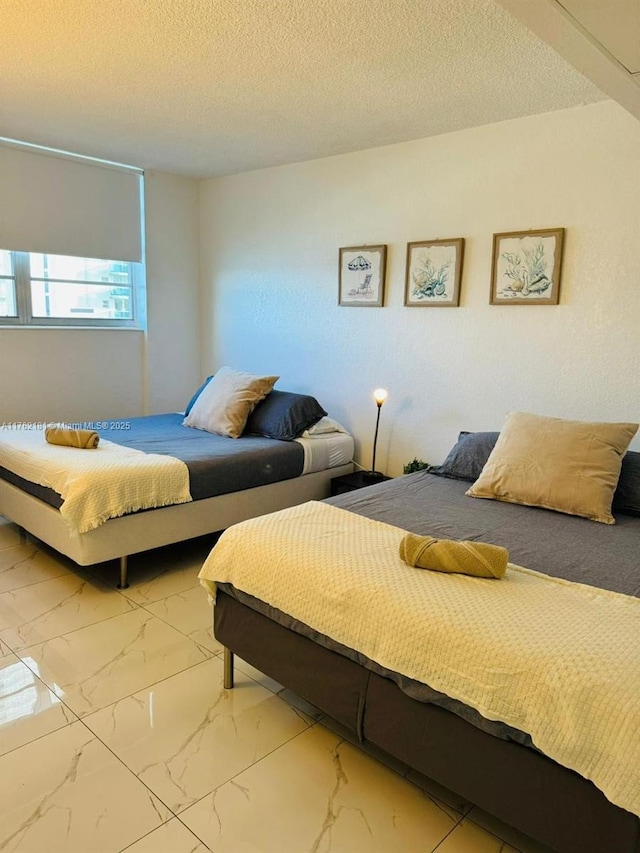 bedroom featuring a textured ceiling and marble finish floor