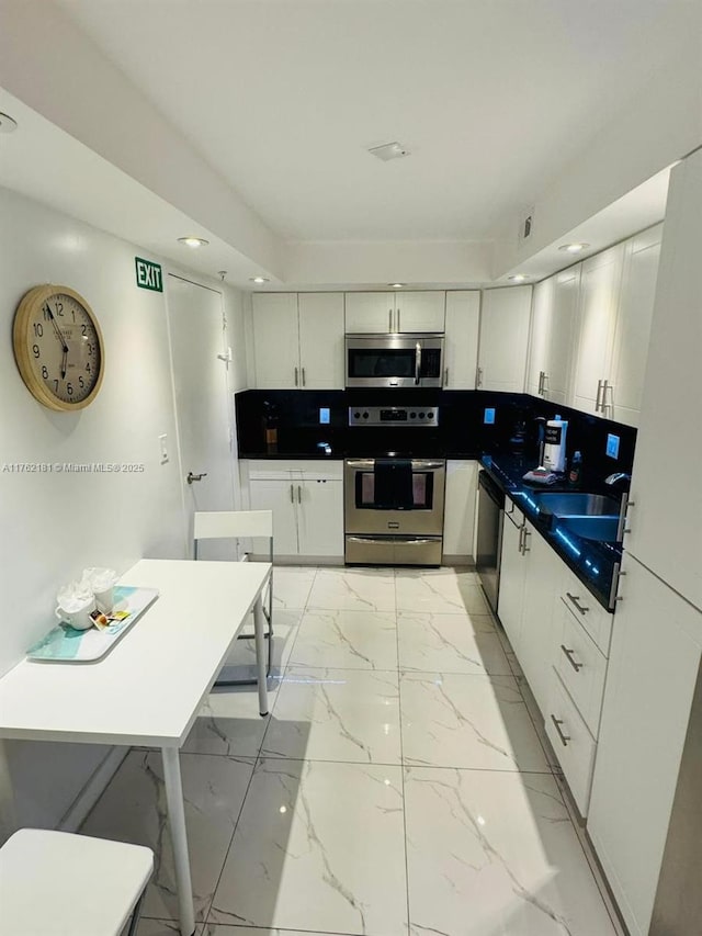 kitchen featuring white cabinetry, marble finish floor, and stainless steel appliances