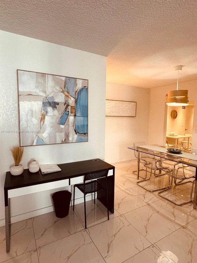 dining room featuring marble finish floor and a textured ceiling