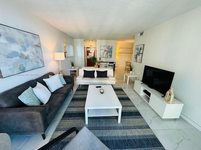 living area with baseboards, visible vents, marble finish floor, and a textured ceiling