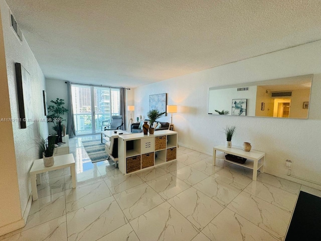 living room featuring visible vents, baseboards, a textured ceiling, and marble finish floor