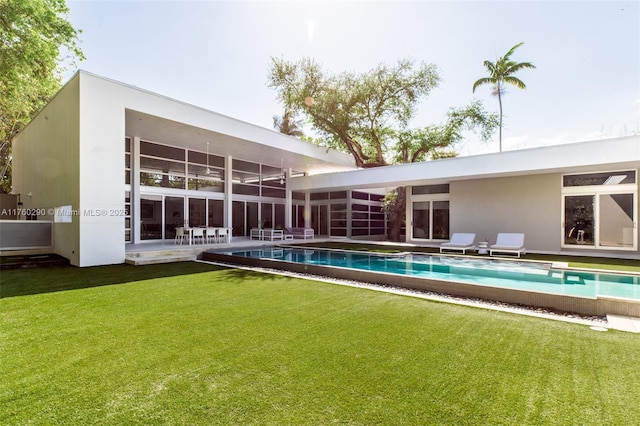 rear view of house featuring a patio, a lawn, and an outdoor pool