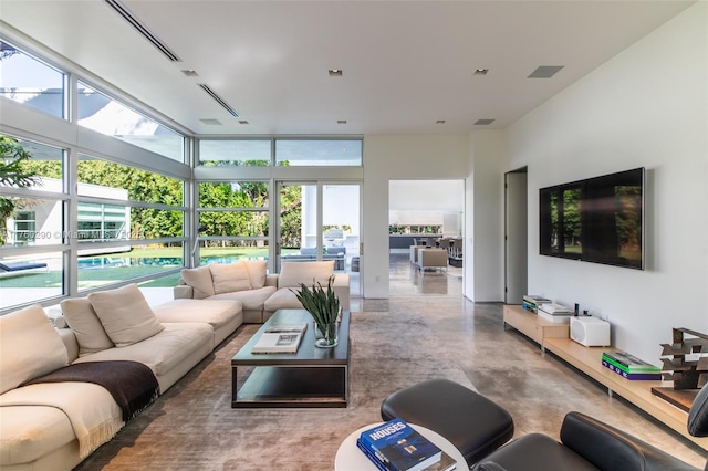 living room with visible vents, finished concrete floors, and floor to ceiling windows