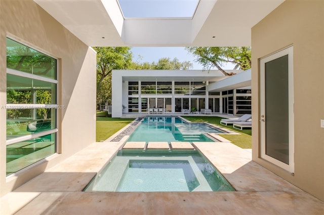 view of swimming pool featuring a patio and a pool with connected hot tub