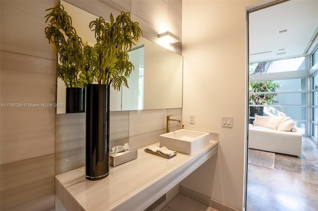 bathroom featuring a sink, concrete floors, and a wall of windows