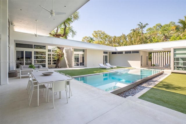 outdoor pool featuring a patio, outdoor dining area, a ceiling fan, and a lawn