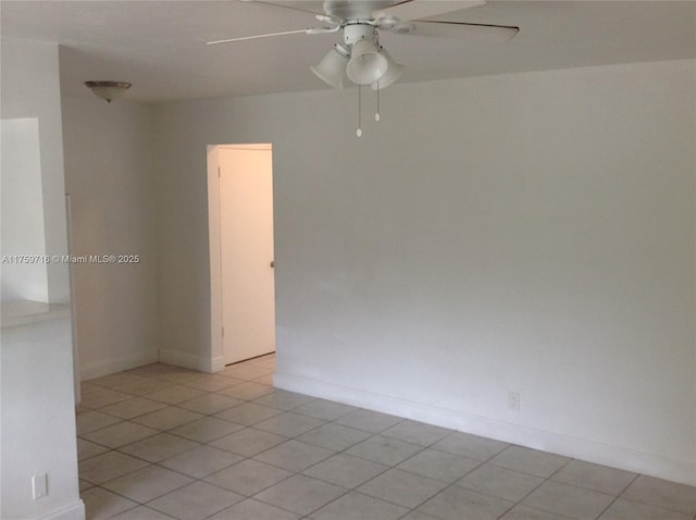 spare room with light tile patterned flooring, baseboards, and a ceiling fan