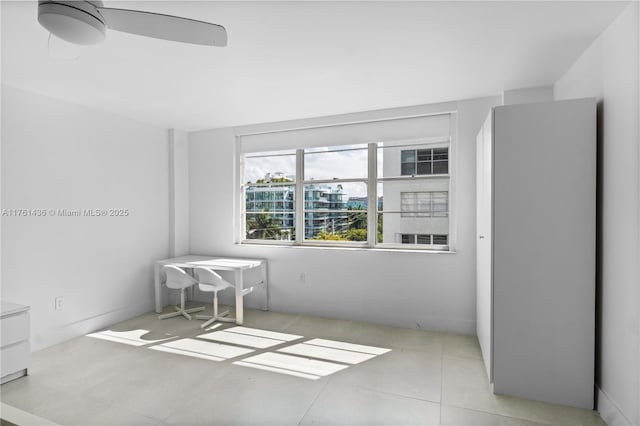 tiled empty room featuring ceiling fan