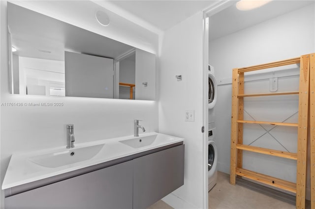 bathroom with double vanity, stacked washer and clothes dryer, concrete flooring, and a sink