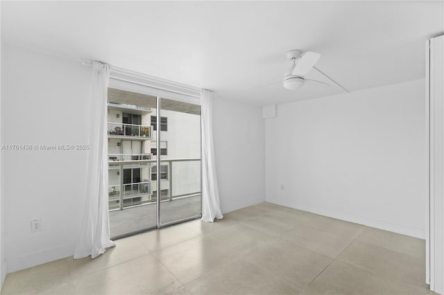 unfurnished room featuring a wall of windows, baseboards, and ceiling fan