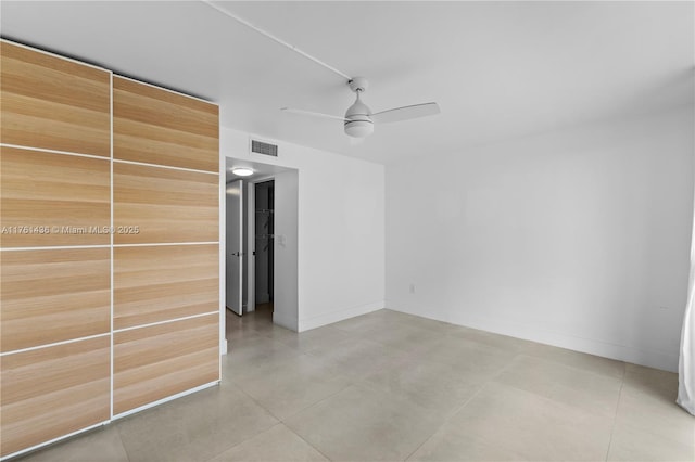 unfurnished room with baseboards, visible vents, and ceiling fan