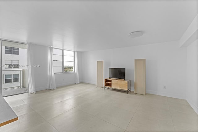 unfurnished living room featuring light tile patterned floors and baseboards