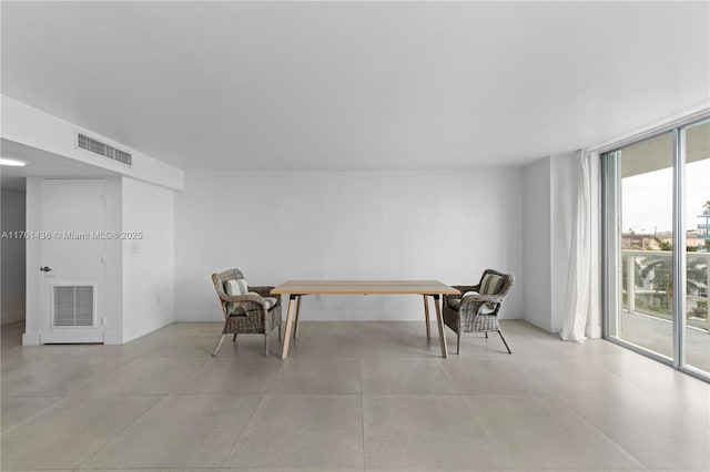 sitting room with floor to ceiling windows, baseboards, and visible vents