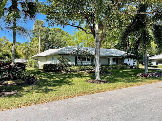 view of front facade with a front lawn, a garage, and stucco siding