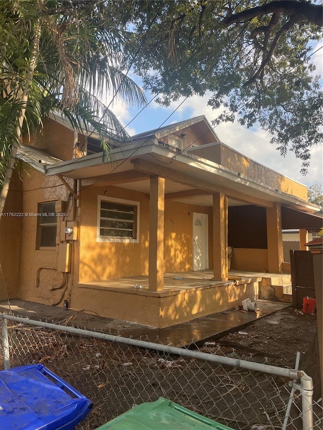 view of home's exterior with stucco siding and fence