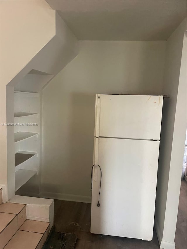 kitchen with wood finished floors, baseboards, and freestanding refrigerator