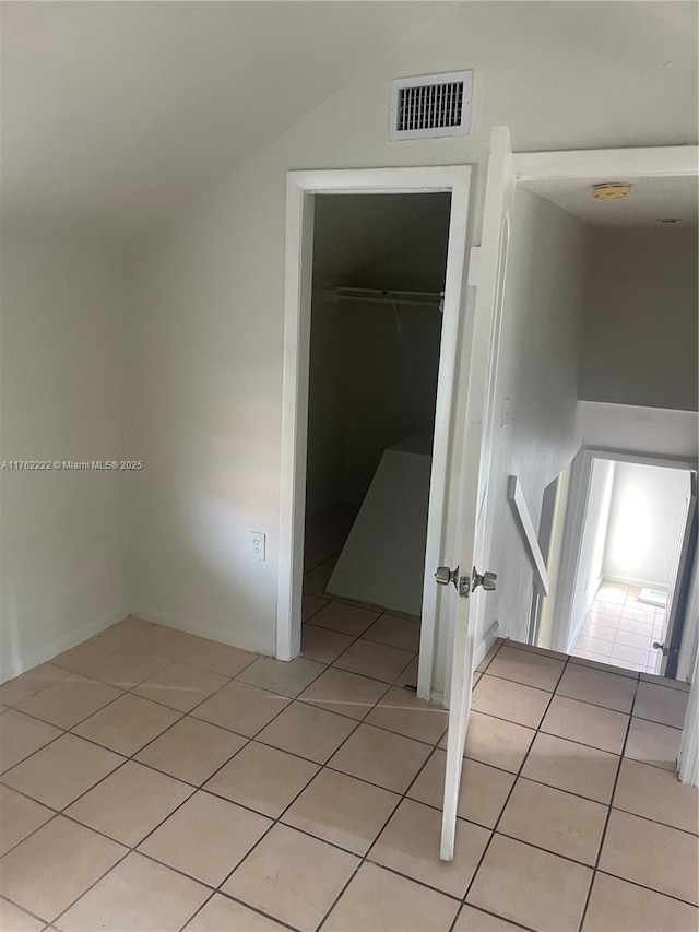 unfurnished bedroom with light tile patterned floors, visible vents, a closet, and a spacious closet