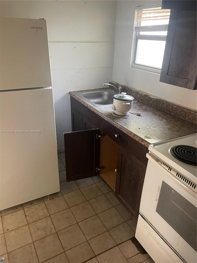 kitchen featuring a sink, white appliances, dark brown cabinets, and light tile patterned floors