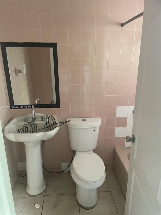 full bathroom with walk in shower, tile patterned floors, toilet, tile walls, and a washtub