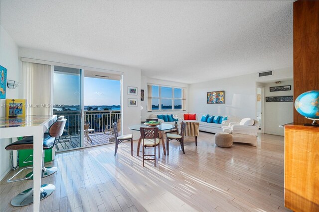 living area featuring visible vents, a textured ceiling, and wood finished floors