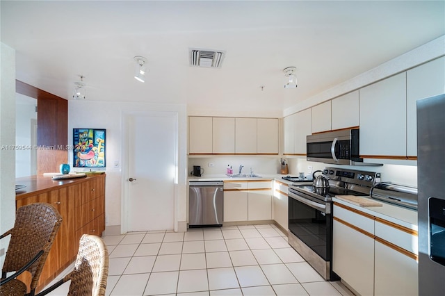 kitchen featuring visible vents, a sink, stainless steel appliances, light countertops, and light tile patterned floors