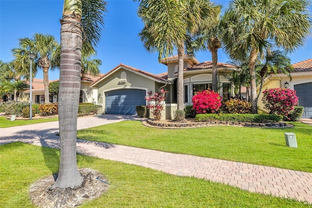 mediterranean / spanish-style house featuring a tile roof, a front yard, stucco siding, driveway, and an attached garage