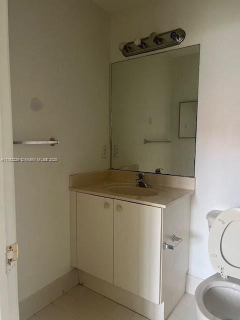 half bath with vanity, tile patterned floors, and toilet