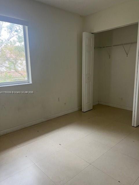 unfurnished bedroom featuring baseboards and a closet